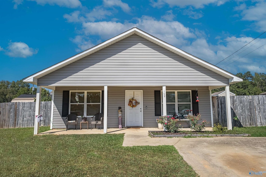 bungalow with covered porch and a front lawn