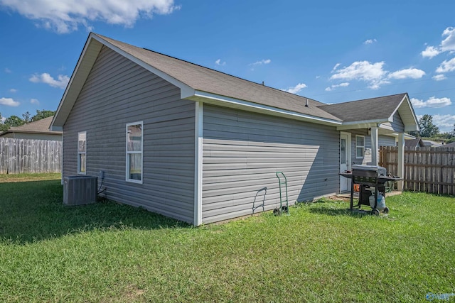 view of side of home with a yard and central AC unit