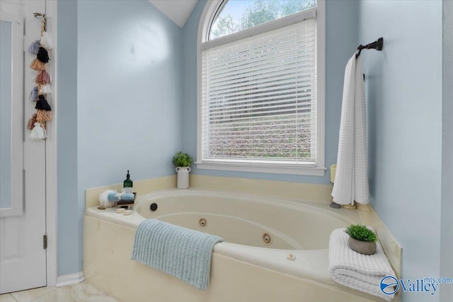 bathroom with a tub, lofted ceiling, and plenty of natural light