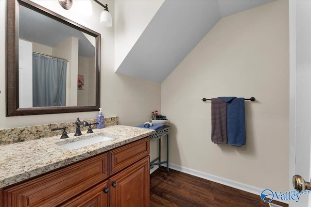 bathroom with lofted ceiling, wood-type flooring, and vanity