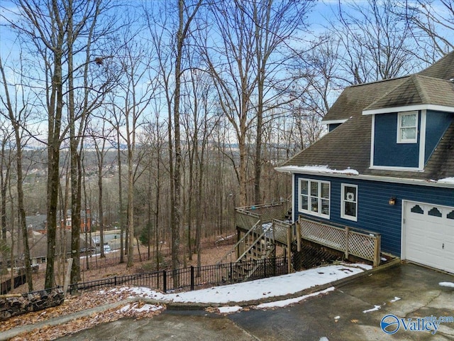 view of snowy exterior featuring a garage