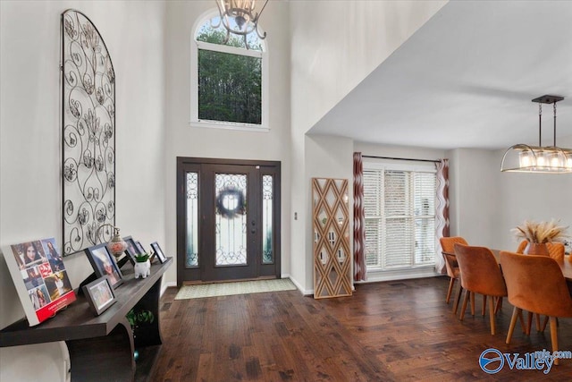 foyer with dark wood-type flooring and a chandelier