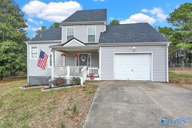 view of property with a porch, a garage, and a front lawn