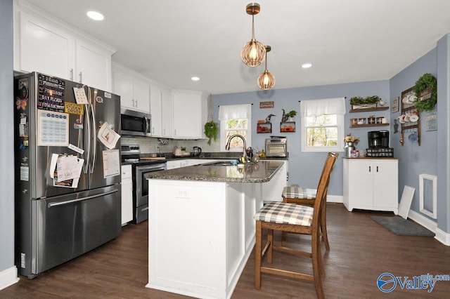 899 Pine Grove Rd, Harvest, AL 35749 - kitchen featuring white cabinets, appliances with stainless steel finishes, decorative light fixtures, a kitchen island with sink, and a sink