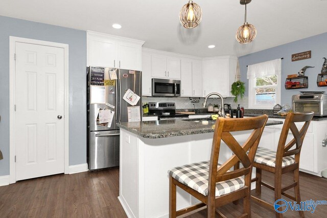 899 Pine Grove Rd, Harvest, AL 35749 - kitchen featuring stainless steel appliances, white cabinetry, a center island, dark stone counters, and decorative light fixtures