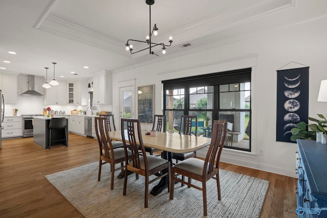 24673 Beacon Cir, Athens, AL 35613 - dining room with crown molding, a tray ceiling, wood finished floors, a chandelier, and recessed lighting