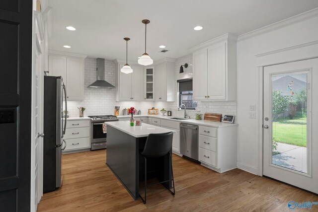 24673 Beacon Cir, Athens, AL 35613 - kitchen featuring appliances with stainless steel finishes, wall chimney exhaust hood, tasteful backsplash, white cabinetry, and light countertops