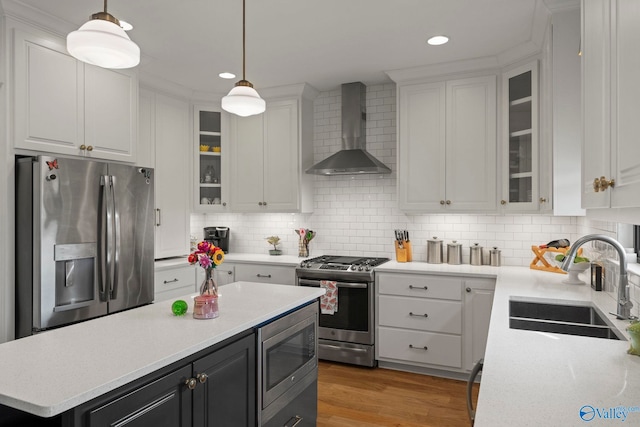 24673 Beacon Cir, Athens, AL 35613 - kitchen featuring wall chimney range hood, stainless steel appliances, a sink, white cabinetry, and light countertops