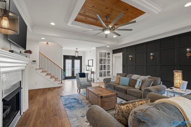24673 Beacon Cir, Athens, AL 35613 - living area featuring a fireplace, a ceiling fan, wood finished floors, ornamental molding, and a raised ceiling
