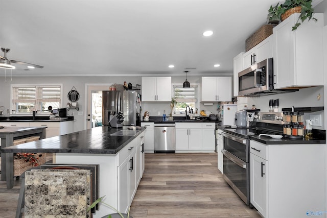 kitchen with plenty of natural light, white cabinetry, a center island, and stainless steel appliances