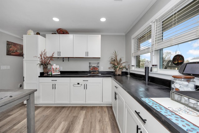 kitchen featuring light hardwood / wood-style floors, white cabinetry, and ornamental molding