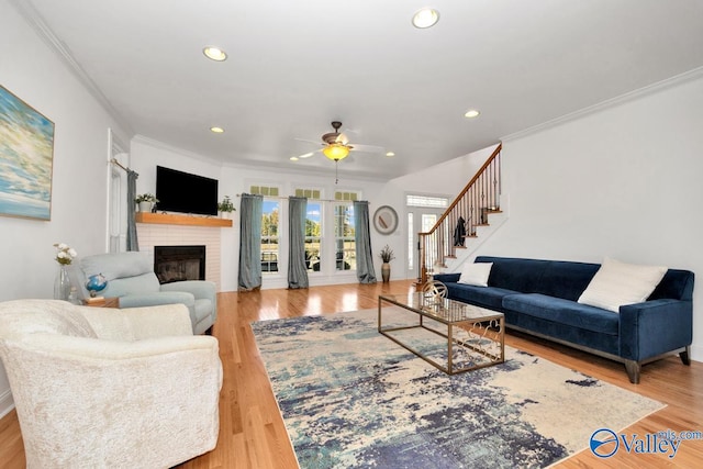 living room with ornamental molding, light hardwood / wood-style floors, and ceiling fan