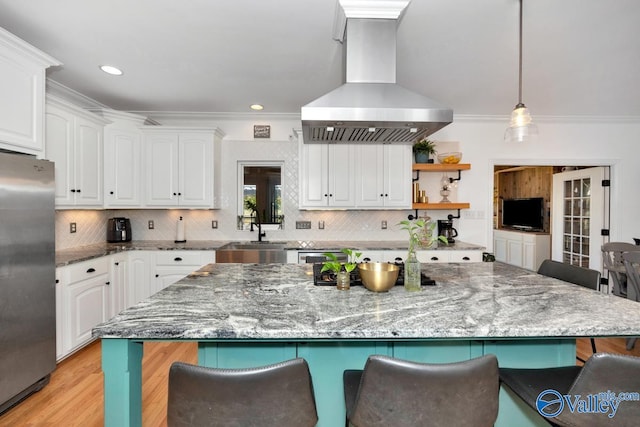 kitchen featuring white cabinetry, extractor fan, dark stone counters, and stainless steel fridge