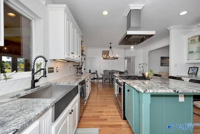 kitchen with a breakfast bar area, white cabinetry, light wood-type flooring, range hood, and stainless steel appliances