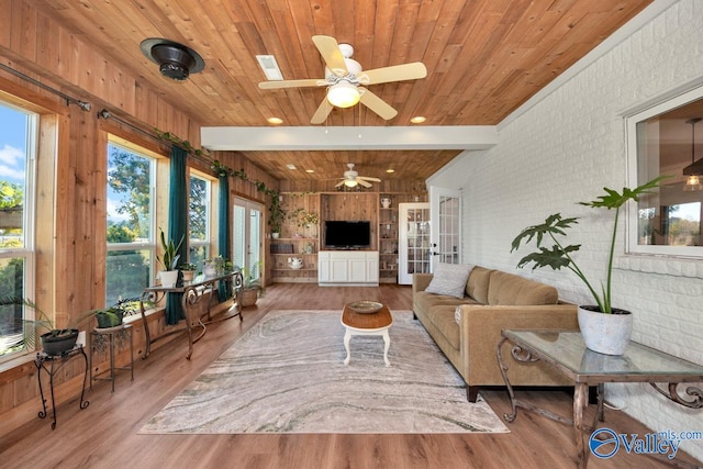 living room with hardwood / wood-style floors, beam ceiling, ceiling fan, and a wealth of natural light