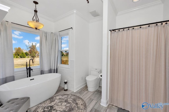 bathroom featuring toilet, crown molding, hardwood / wood-style floors, and a bathtub