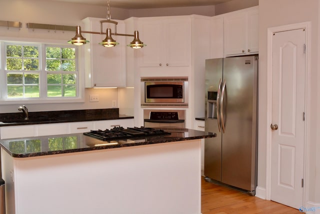 kitchen featuring white cabinets, stainless steel appliances, sink, and light hardwood / wood-style flooring