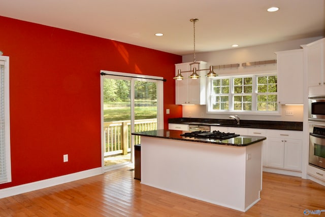 kitchen featuring light wood-type flooring, plenty of natural light, white cabinetry, and stainless steel appliances