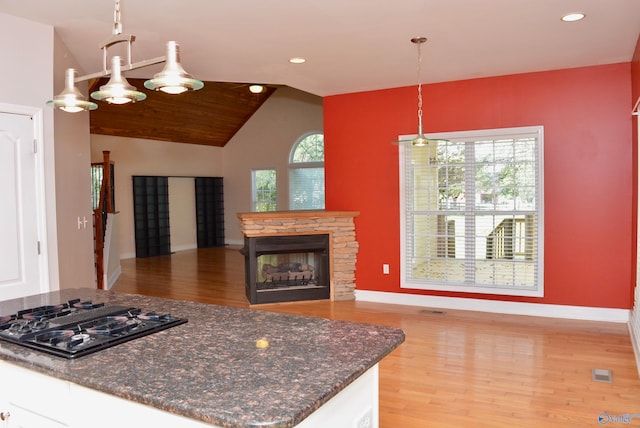 kitchen with black gas cooktop, pendant lighting, white cabinetry, vaulted ceiling, and light hardwood / wood-style flooring