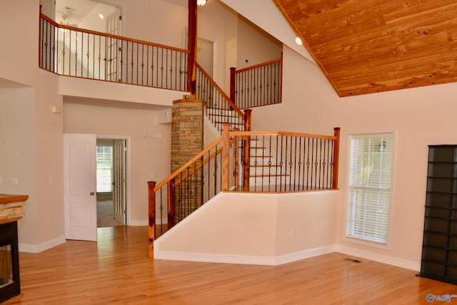 stairway featuring hardwood / wood-style flooring, high vaulted ceiling, and wood ceiling