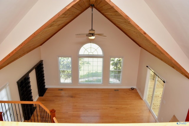 additional living space featuring plenty of natural light, light hardwood / wood-style floors, lofted ceiling with beams, and ceiling fan