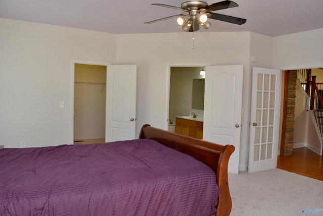 bedroom featuring ceiling fan, sink, carpet, a closet, and a spacious closet