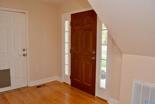 foyer entrance featuring lofted ceiling and light hardwood / wood-style floors