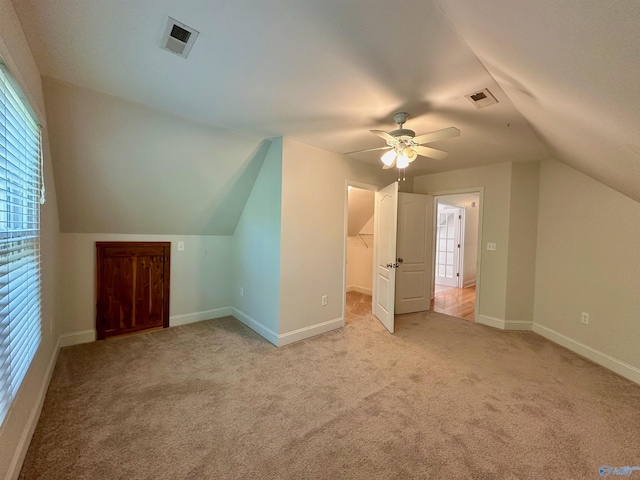 additional living space with lofted ceiling, light colored carpet, and ceiling fan