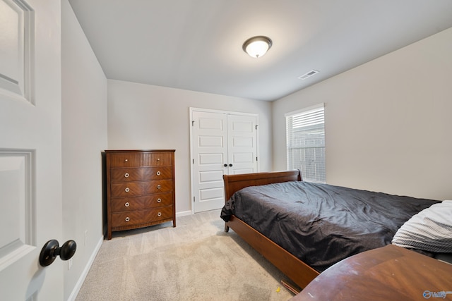 bedroom featuring light carpet and a closet