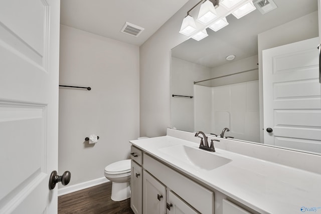 bathroom with hardwood / wood-style flooring, toilet, vanity, and walk in shower