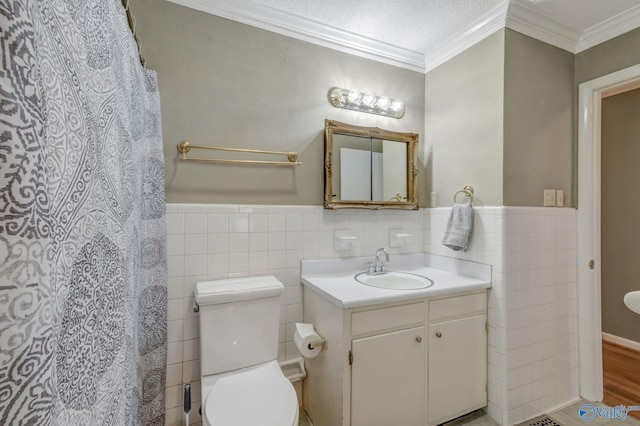 222 Lakewood Dr, Scottsboro, AL 35769 - full bathroom with a wainscoted wall, toilet, vanity, ornamental molding, and tile walls