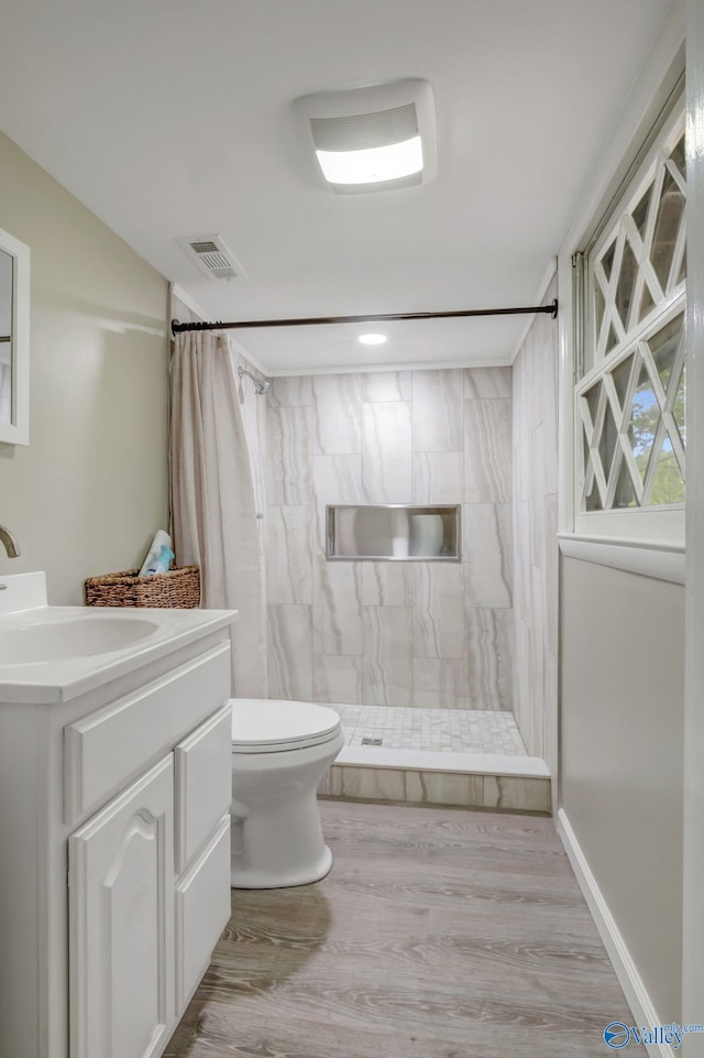 222 Lakewood Dr, Scottsboro, AL 35769 - bathroom featuring a tile shower, toilet, vanity, and visible vents
