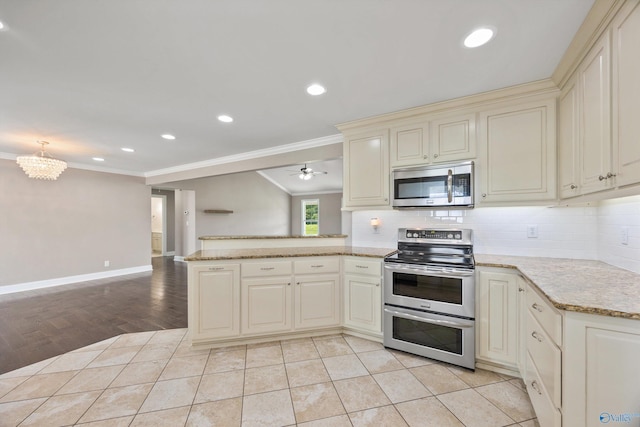 368 Halston Rd, Arab, AL 35016 - kitchen with appliances with stainless steel finishes, cream cabinets, a peninsula, open floor plan, and tasteful backsplash