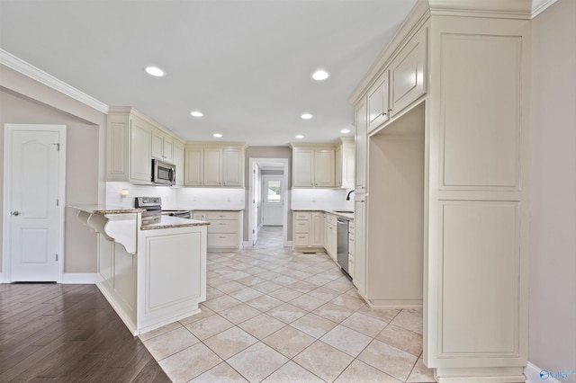 368 Halston Rd, Arab, AL 35016 - kitchen with appliances with stainless steel finishes, cream cabinets, a peninsula, light stone counters, and recessed lighting