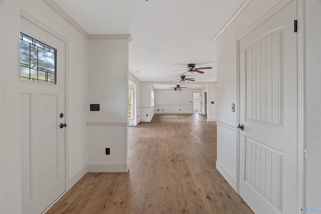 entryway with ornamental molding, ceiling fan, light hardwood / wood-style floors, and plenty of natural light