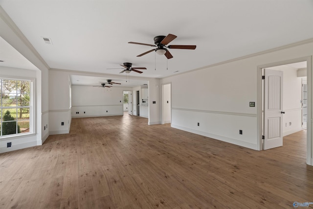 unfurnished living room with hardwood / wood-style floors, ceiling fan, and crown molding