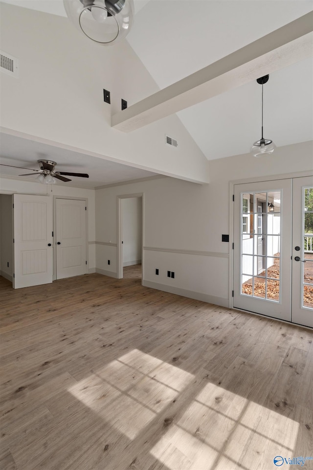 unfurnished living room featuring french doors, high vaulted ceiling, and light hardwood / wood-style flooring