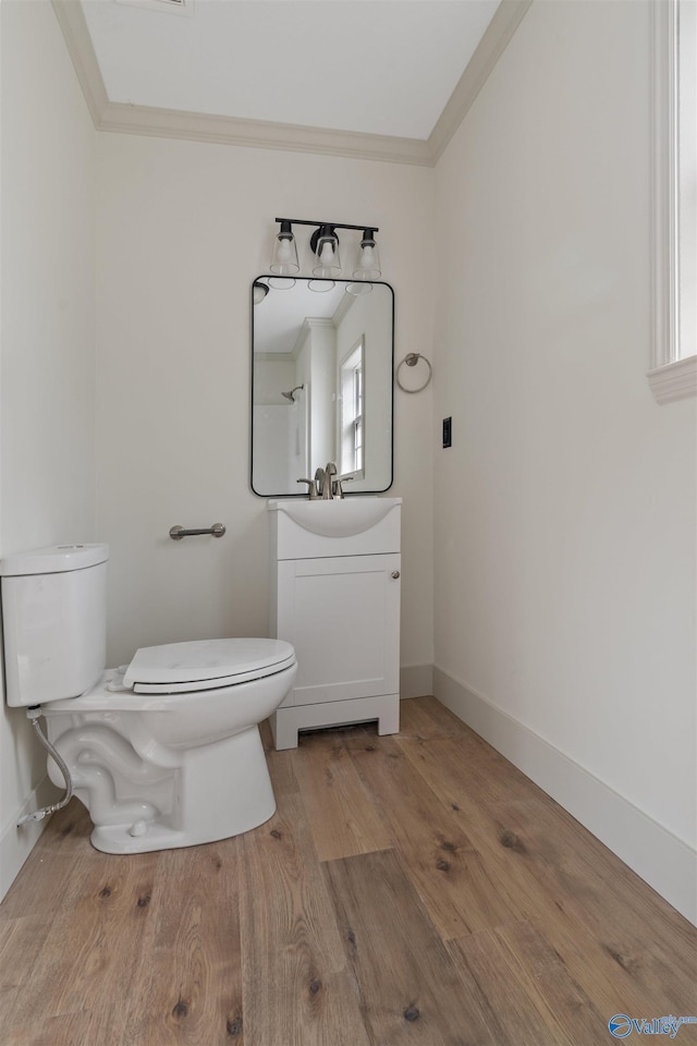 bathroom featuring ornamental molding, hardwood / wood-style floors, vanity, and toilet