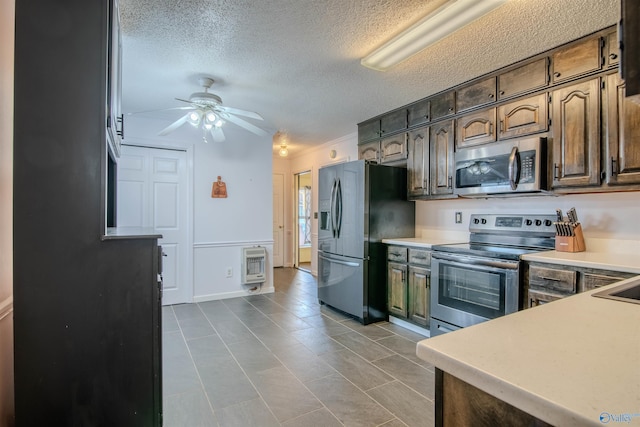 kitchen with dark brown cabinets, stainless steel appliances, heating unit, a textured ceiling, and ceiling fan