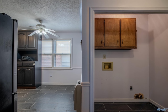 washroom with a textured ceiling, ceiling fan, electric dryer hookup, washer hookup, and cabinets