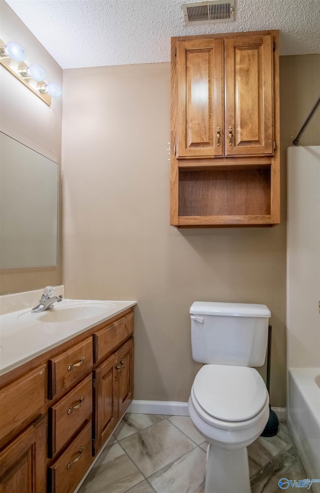 bathroom with vanity, a textured ceiling, and toilet