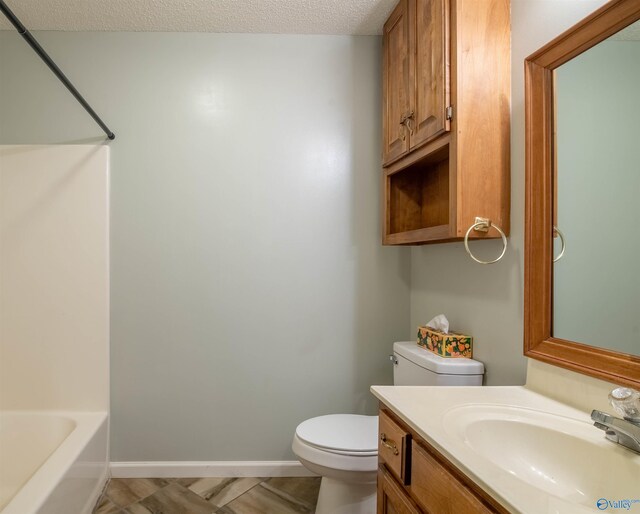 full bathroom with vanity, shower / tub combination, a textured ceiling, and toilet