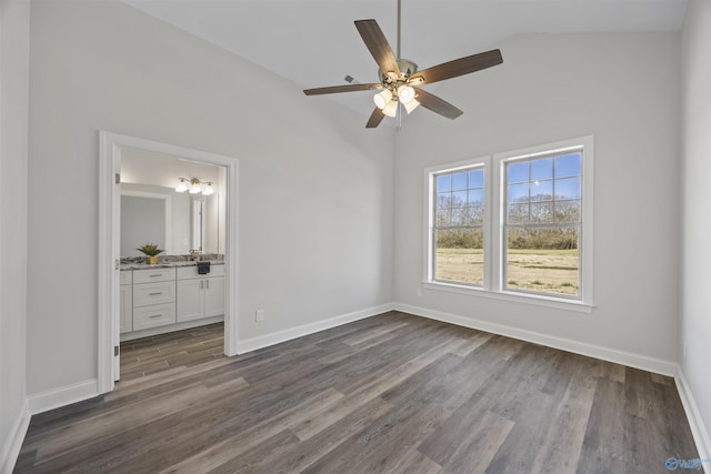 unfurnished bedroom with ensuite bathroom, dark wood-type flooring, a ceiling fan, and baseboards