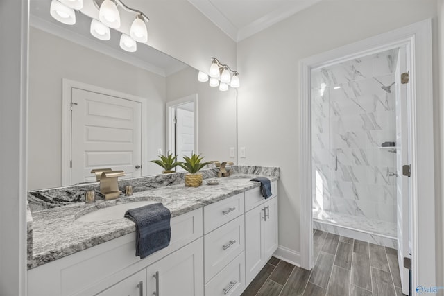 full bathroom with double vanity, wood tiled floor, crown molding, a shower stall, and a sink