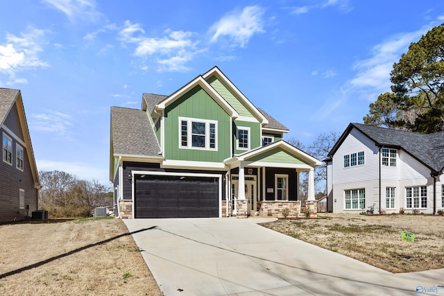 craftsman-style house with roof with shingles, central air condition unit, board and batten siding, stone siding, and driveway