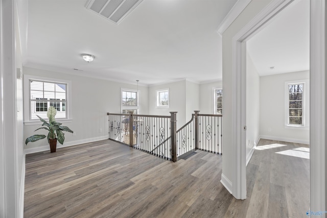 hall with wood finished floors, an upstairs landing, visible vents, and baseboards