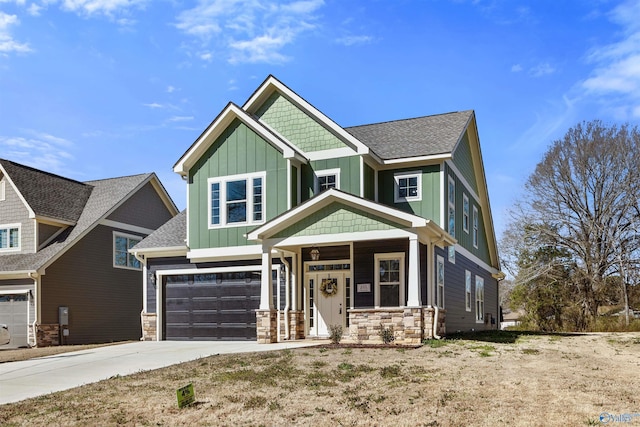 craftsman-style house featuring a garage, a shingled roof, stone siding, driveway, and board and batten siding