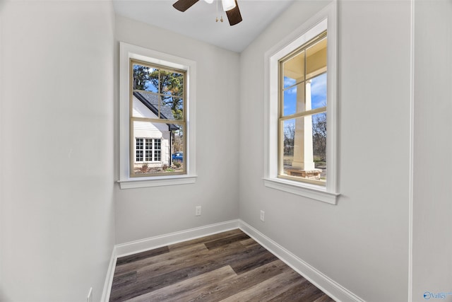 unfurnished room with a ceiling fan, dark wood-style flooring, and baseboards