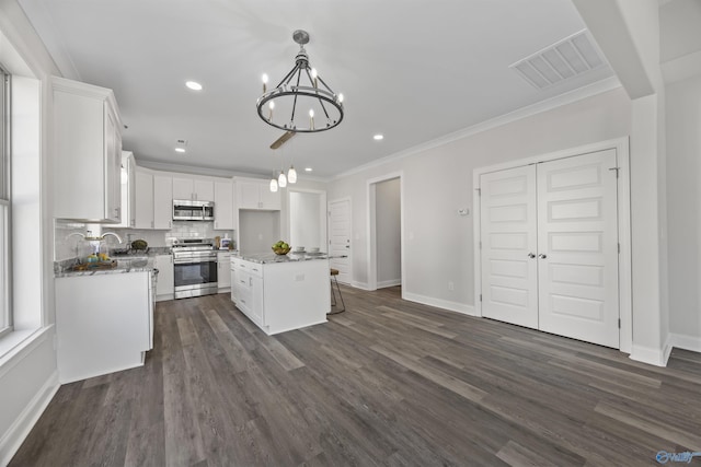 kitchen featuring visible vents, decorative backsplash, appliances with stainless steel finishes, crown molding, and white cabinetry