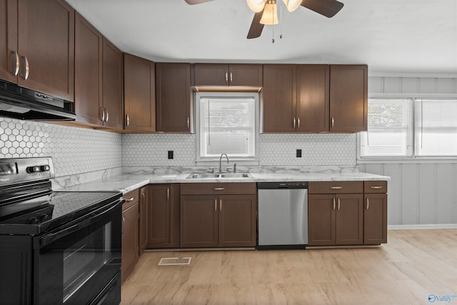 kitchen featuring black range with electric stovetop, sink, stainless steel dishwasher, range hood, and light wood-type flooring